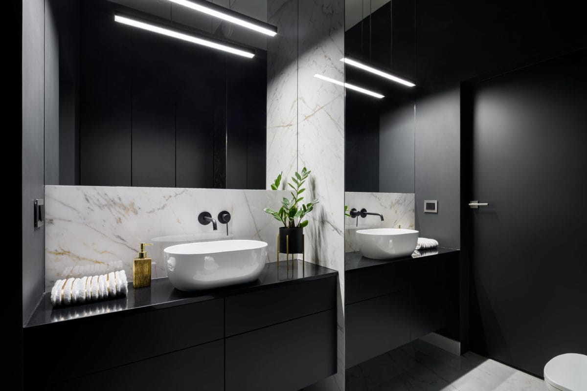 Elegant black bathroom with mirror wall and decorative marble tiles