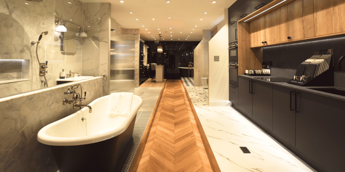 Luxury bathroom showroom with freestanding bath, marble walls and herringbone flooring